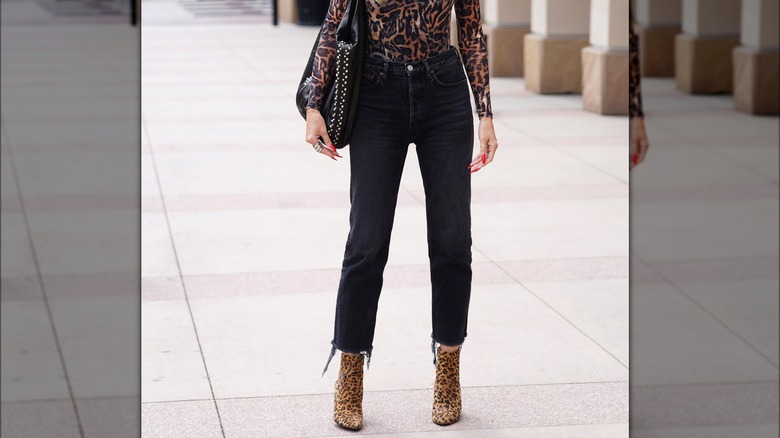 Jeans neri cropped con stivaletti con stampa animalier