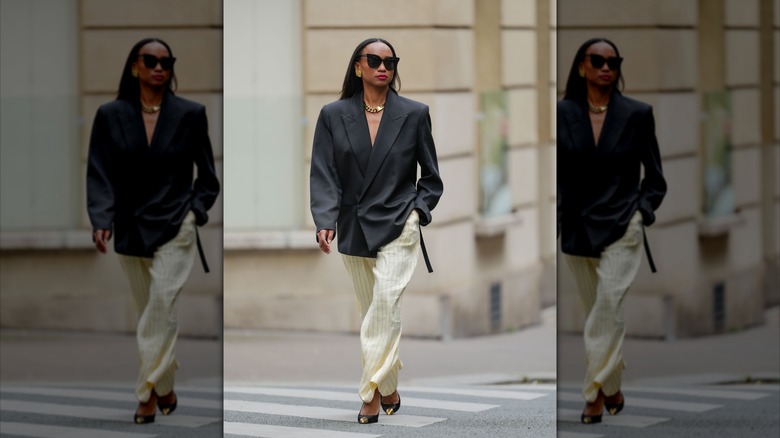 Una donna che indossa blazer e pantaloni a righe beige