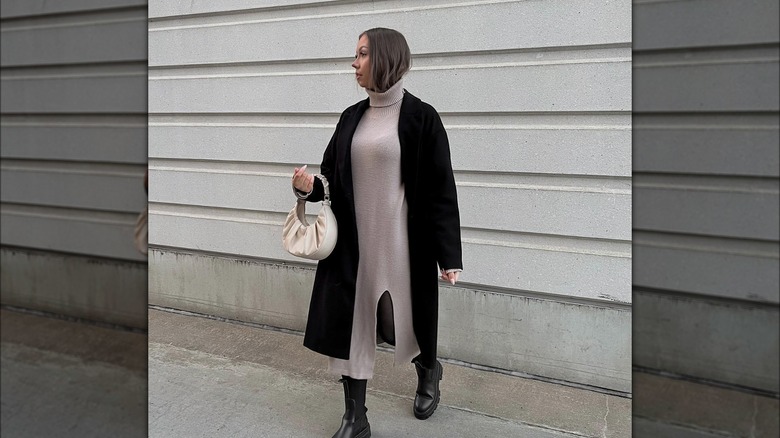 Ragazza che indossa un trench con un maxi abito in maglia