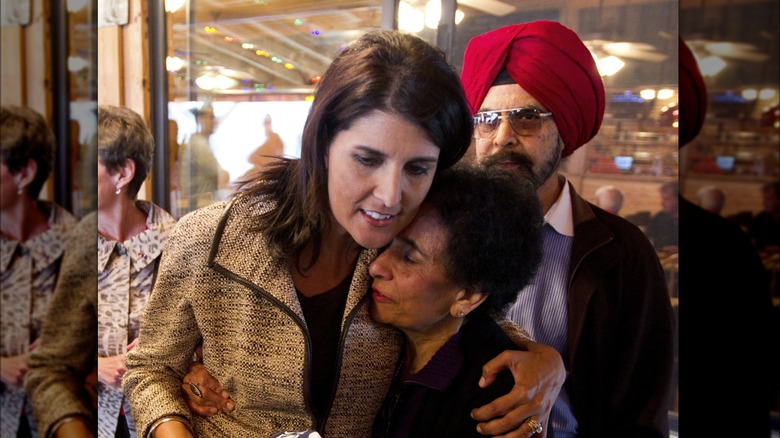 Nikki Haley abbraccia sua madre, suo padre in piedi dietro di loro