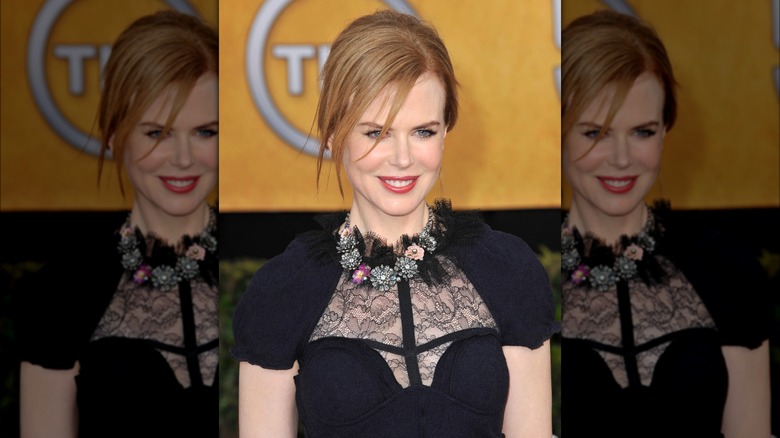 Nicole Kidman indossa un abito nero con pannelli di pizzo e una grossa collana floreale