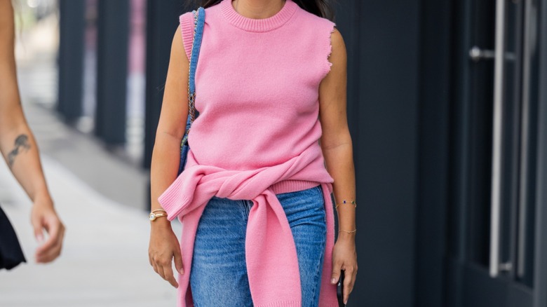 donna che indossa un maglione rosa intorno alla vita