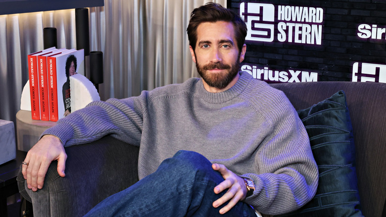 Jake Gyllenhaal seduto su un divano sorridente