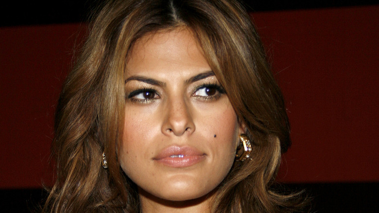 Eva Mendes indossa grandi orecchini a cerchio d'oro e guarda di lato