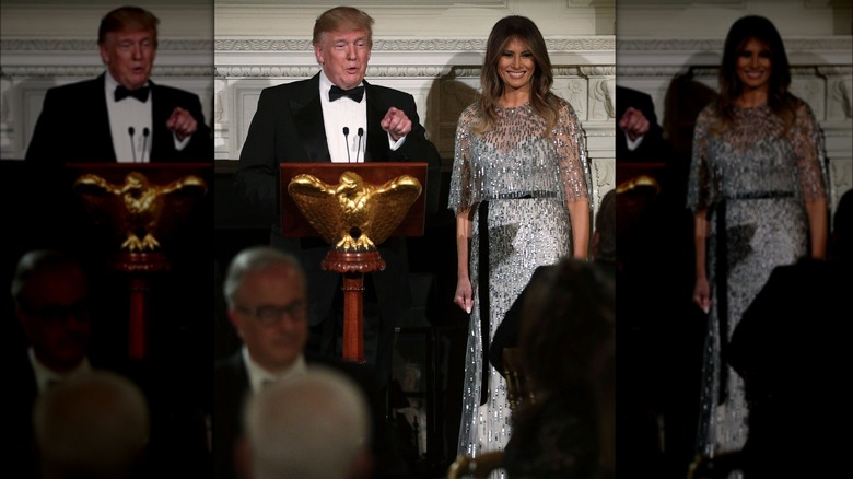 Melania Trump in piedi con Donald Trump mentre fa un discorso