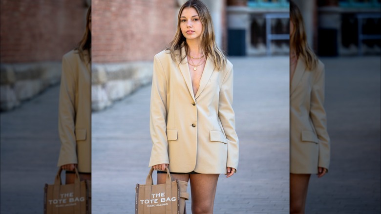 Donna che indossa blazer marrone chiaro e pantaloni caldi