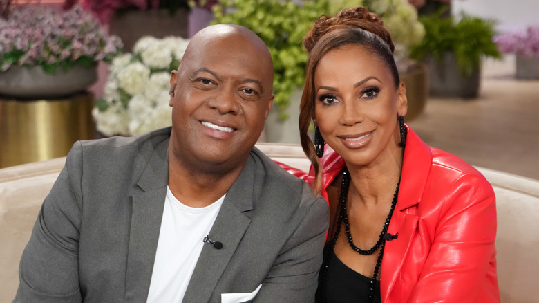 Rodney Peete e Holly Robinson Peete si siedono su un divano.