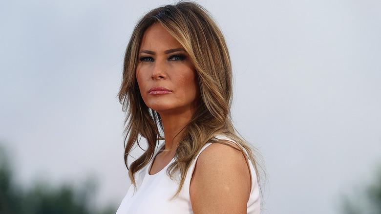 Melania Trump abito bianco accigliata