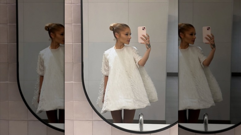 Ariana Grande indossa un abito bianco gonfio per farsi un selfie in bagno.