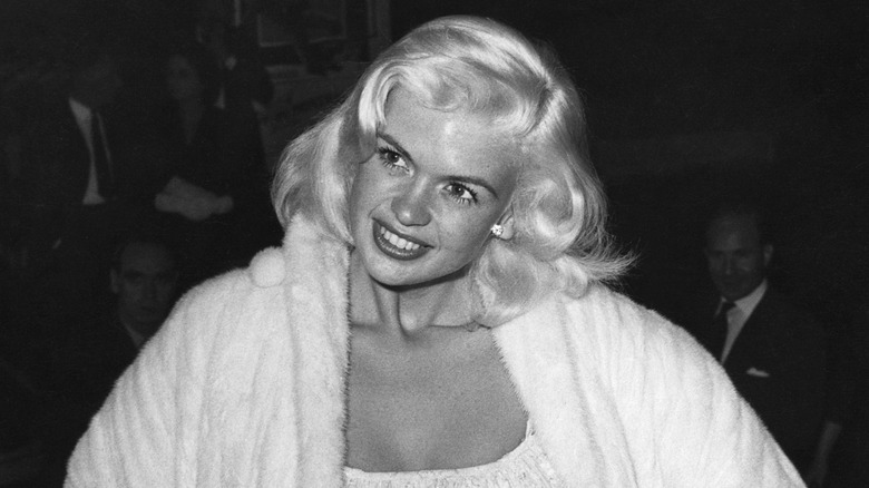 Jayne Mansfield posa in camice bianco durante un evento negli anni '50.