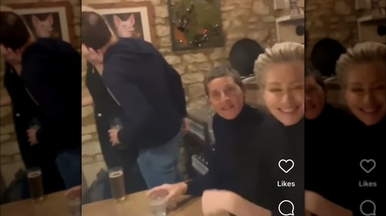 Ellen DeGeneres e la moglie Portia de Rossi vestite di nero in un pub