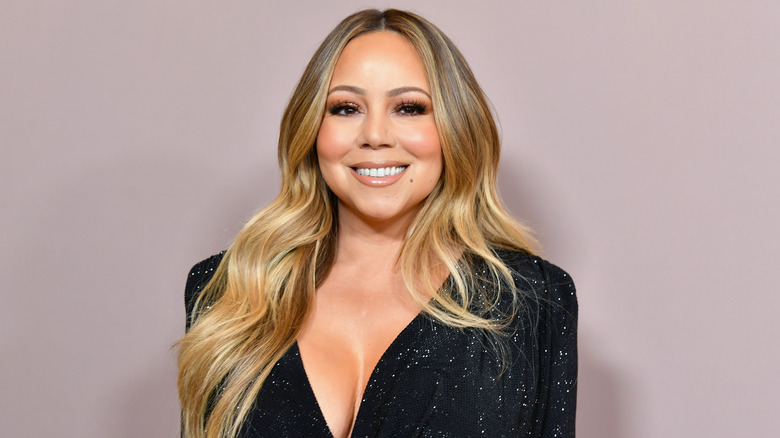 Mariah Carey sorride con un vestito nero scintillante