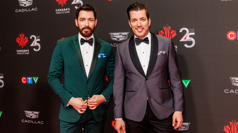 I Property Brothers posano sul tappeto rosso con giacche verdi e viola e papillon