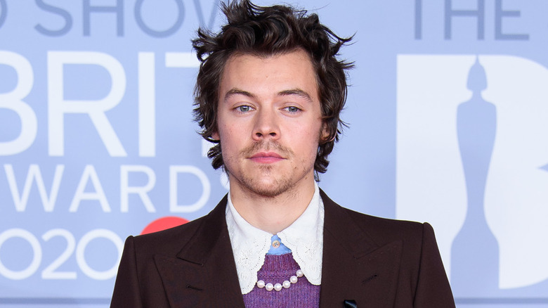 Harry Styles indossa una collana di perle e una giacca