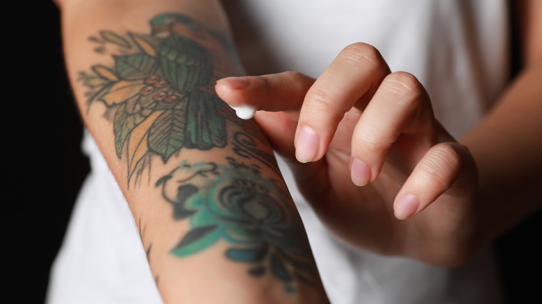 Donna che applica la crema al tatuaggio